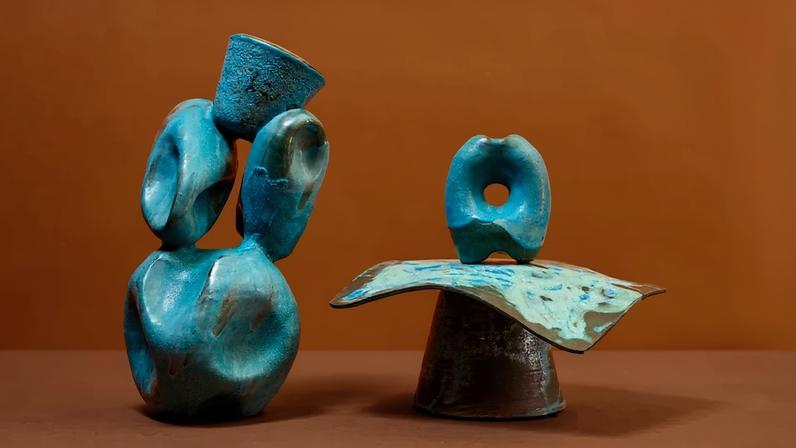 Two bronze sculptures comprised of thick circles on what appear to be unsteady organize looking bases.