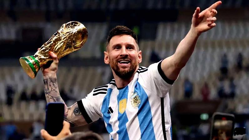 Lionel Messi carrega com uma das mãos o troféu da Copa do Mundo da Fifa de Futebol Masculino em 2022, no Catar