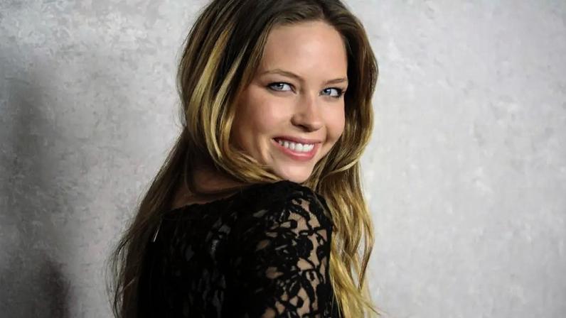 A atriz Daveigh Chase sorri enquanto olha por cima do ombro para a estreia de 2011 de sua série Big Love, da HBO.