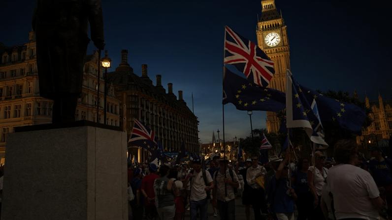 Pessoas passam diante da Torre Elizabeth, o Big Ben, durante a 4ª Marcha Nacional pela Reintegração, em Londres, ato que marcou os dez anos do referendo do Brexit e defendeu maior aproximação entre o Reino Unido e a União Europeia, em 20 de junho de 2026.