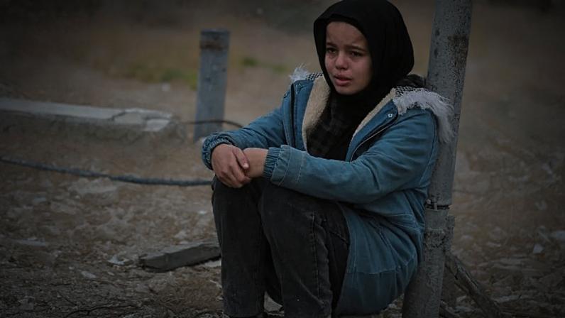 Uma menina entre as ruínas de edifícios em Gaza