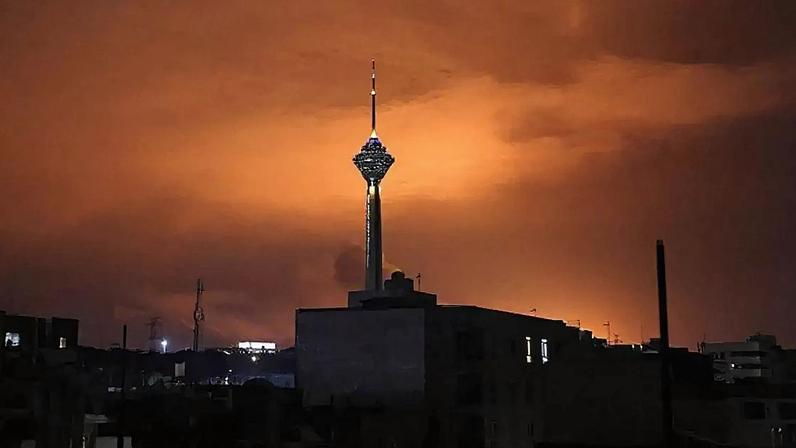 A Torre Milad, a mais alta do Irã, com 435 metros de altura, é vista em Teerã sob um céu iluminado após ataques aéreos de terça-feira