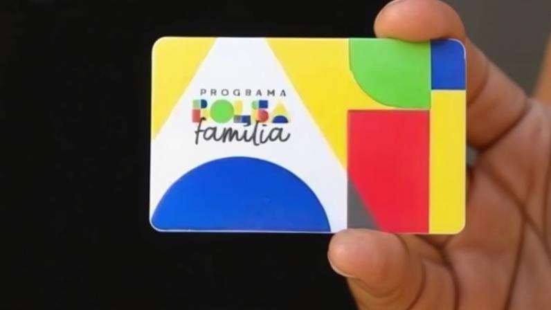 Pessoa segurando cartão do Bolsa Família.