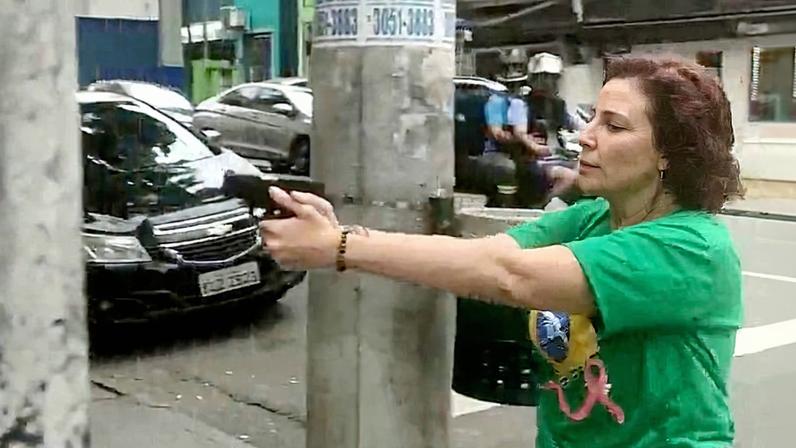 A ex-deputada federal Carla Zambelli de arma em punho voltada a Luan Araújo