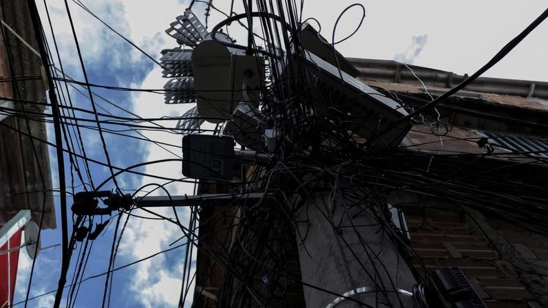 Poste com "gatos" de energia elétrica em uma comunidade da zona norte do Rio de Janeiro