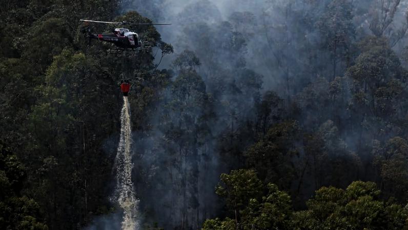 Helicóptero combate incêndio em mata próxima ao bairro de Perus, margeando o Rodoanel em São Paulo, durante a onda de calor provocada pelo El Niño entre 2023 e 2024