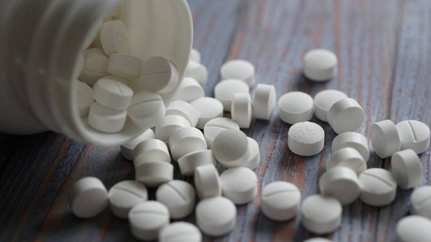 Comprimidos espalhados em uma mesa de madeira