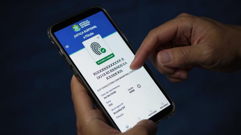Cidadão com o celular aberto no aplicativo do e-Título