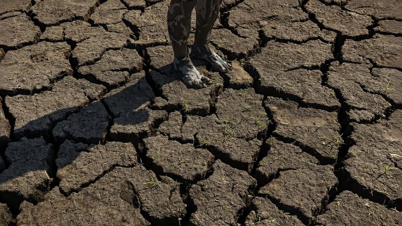 Pés enlameados de pessoa após caminhada pelo leito seco de um lago na comunidade quilombola Saracura, na área de várzea do rio Amazonas, próxima a Santarém, no Pará