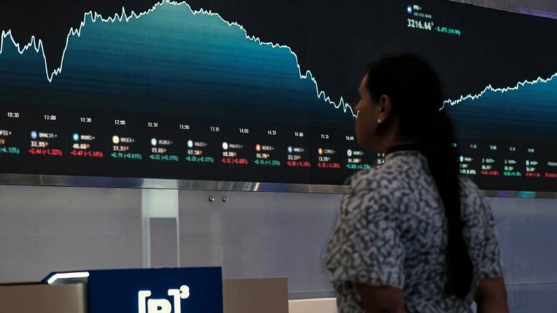 Mulher em frente a um gráfico na B3, a Bolsa de Valores do Brasil