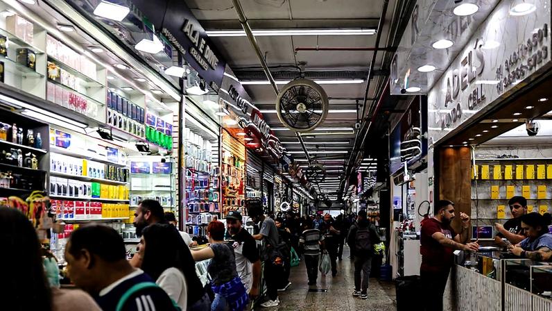 Pessoas circulam pelos corredores da galeria Pajé, tradicional centro de compras localizado na rua 25 de Março, no centro de São Paulo