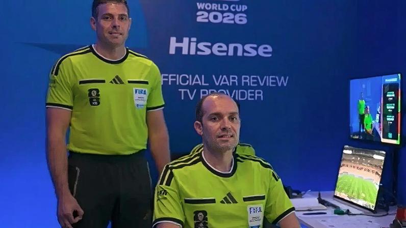 Captura de tela de transmissão da Fifa mostra o gesto de 'OK invertido' feito por Shaun Evans, à esquerda