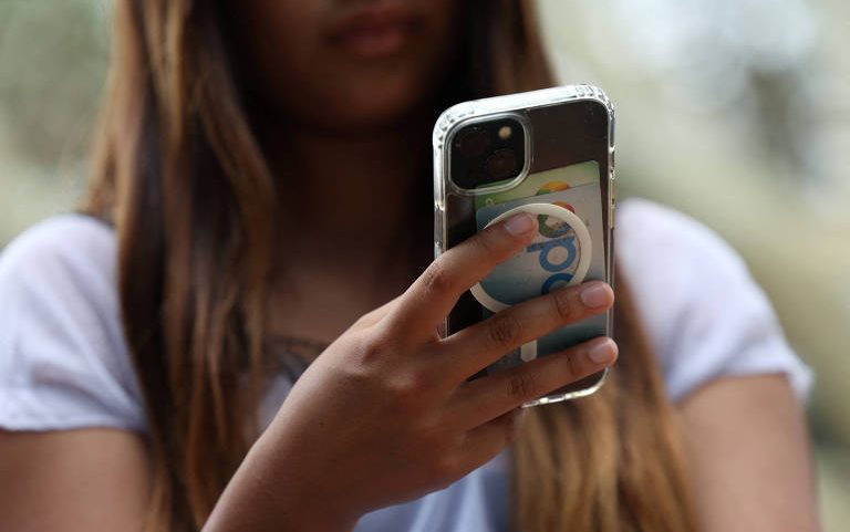 Adolescente mexe em celular em Sydney, na Austrália; país baniu menores de 16 anos das redes sociais