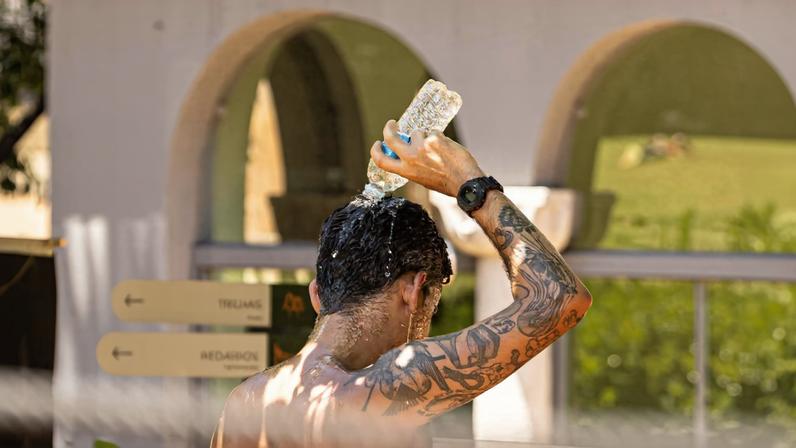 Homem se refresca no Parque Augusta, centro de São Paulo, em dia de calor intenso na capital
