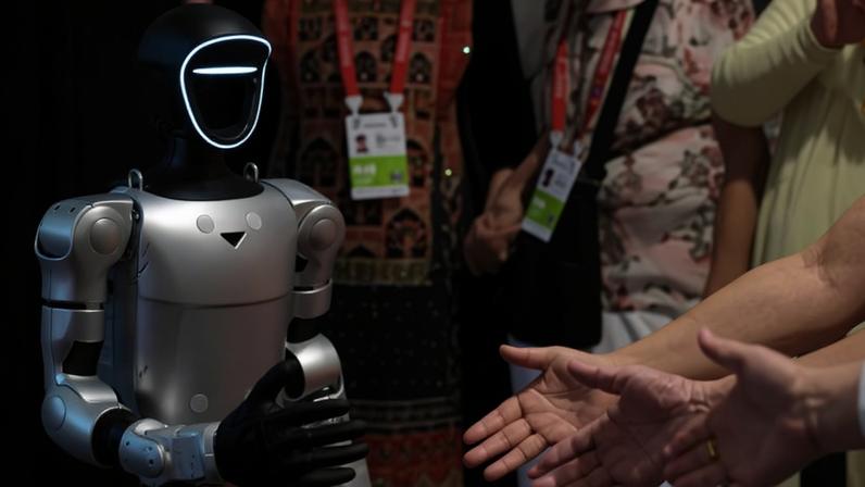 Visitantes interagem com um robô da Unitree Robotics durante uma exposição de produtos de consumo, em Haikou, na província de Hainan, no sul da China.
