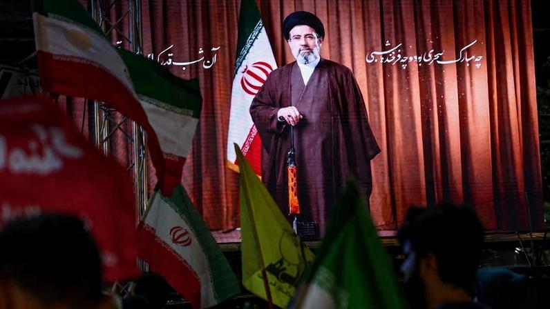 Imagem de Mojtaba Khamenei com uma arma é exibida durante manifestação em apoio ao regime iraniano em Teerã, capital do Irã