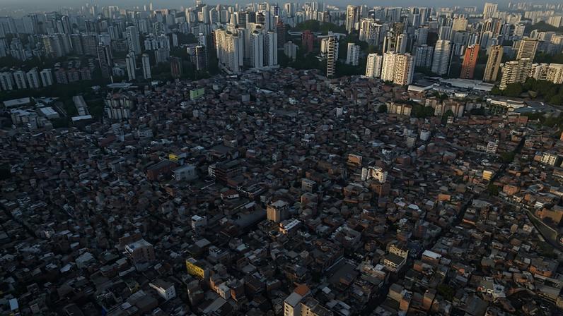 Vista aérea panorâmica da comunidade de Paraisópolis, localizada na zona sul da cidade de São Paulo, mostra contraste entre o adensamento habitacional da periferia e os edifícios de alto padrão ao fundo