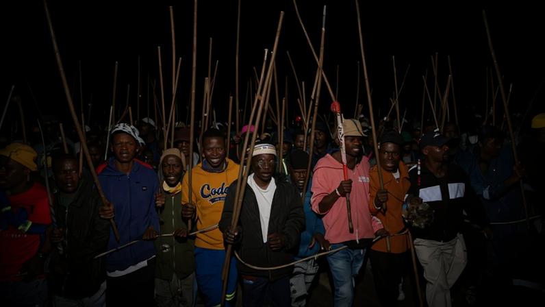 Manifestantes carregam bastões durante um protesto que pede a deportação de imigrantes, em Joanesburgo - Ihsaan Haffejee - 5.jun.26/Reuters