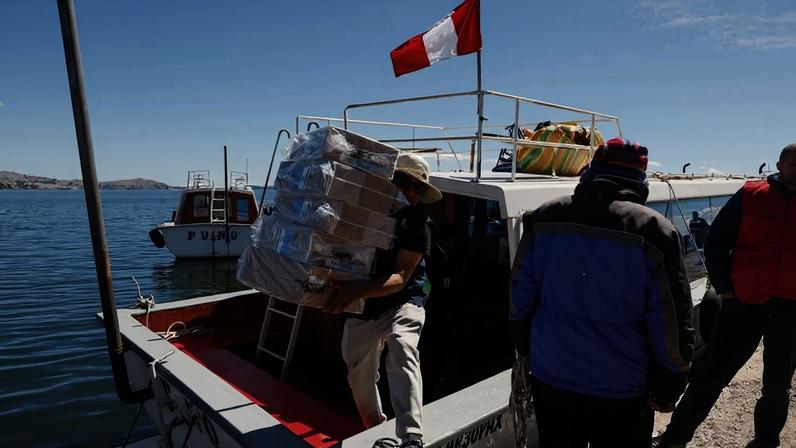 Funcionário do Onpe (Escritório Nacional de Processos Eleitorais) descarrega material eleitoral de um barco na ilha de Amantani, no Lago Titicaca, no sul do Peru
