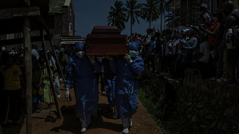 Profissionais de saúde carregam um caixão com o corpo do reverendo Sylvestre Atama, um pregador popular e carismático que morreu de ebola na cidade mineradora de Mongbwalu, República Democrática do Congo