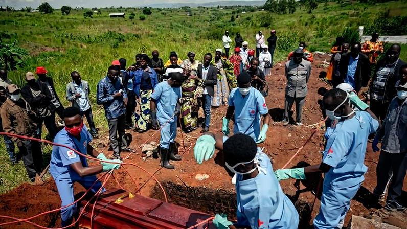 Familiares choram enquanto membros de uma equipe da Cruz Vermelha Congolesa se preparam para baixar o caixão de uma mulher com suspeita de ter morrido de Ebola, como parte de seu sepultamento seguro em um cemitério em Bunia, em 7 de junho de 2026