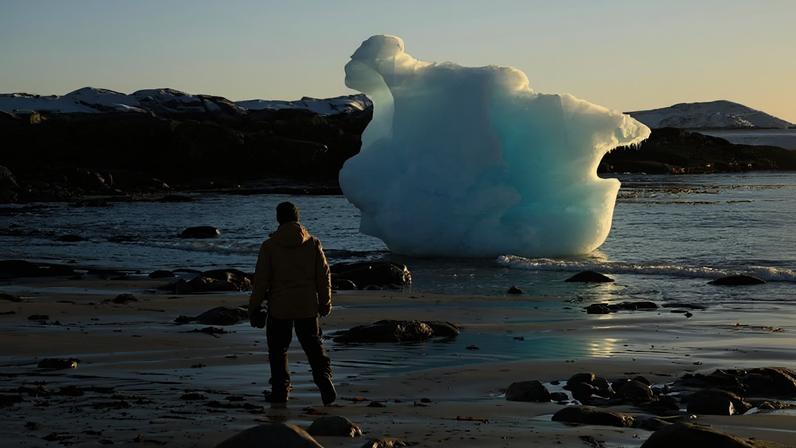 Pessoa em frente a um bloco de gelo na costa da cidade de Nuuk, no oeste da Groenlândia