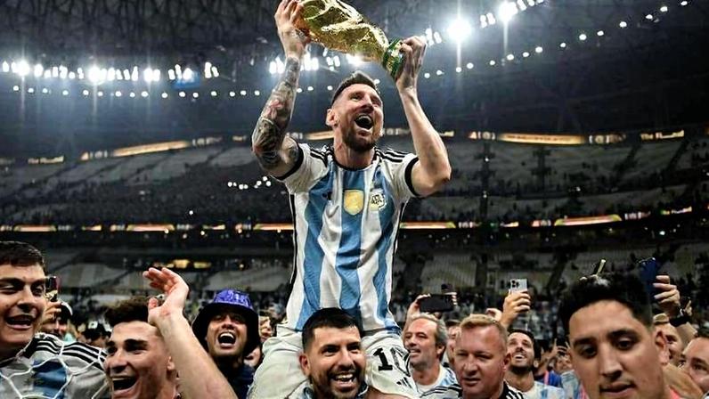 O jogador argentino Lionel Messi ergue o troféu da Copa do Mundo enquanto é carregado nos ombros pelo ex-jogador Sergio Agüero durante as celebrações da conquista da Argentina na Copa do Mundo de 2022
