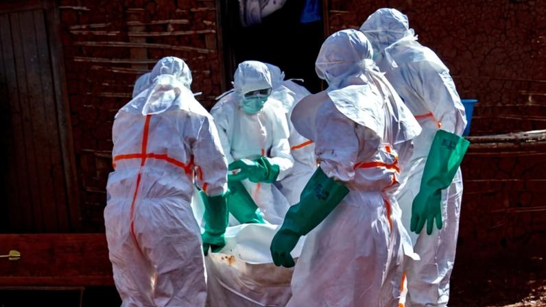 Trabalhadores da Cruz Vermelha carregam corpo de homem vítima do ebola na província de Ituri, na República Democrática do Congo