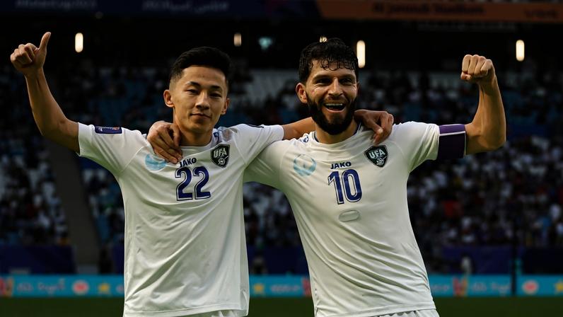 Os jogadores uzbeques Abbosbek Fayzullayev e Jaloliddin Masharipov comemoram gol contra a Tailândia