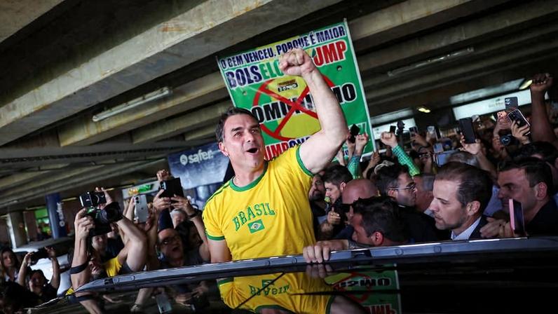 O senador Flávio Bolsonaro (PL-RJ) cercado de apoiadores ao desembarcar em Brasília após viagem aos EUA