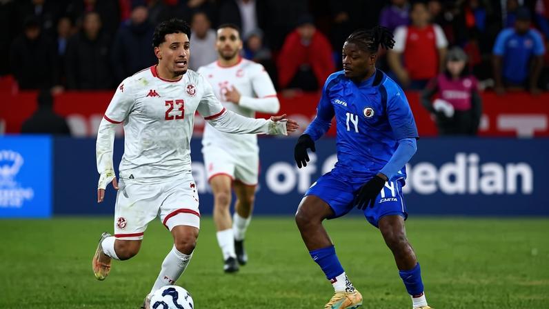 Leverton Pierre, jogador com uniforme azul do Haiti, em amistoso contra a Tunísia