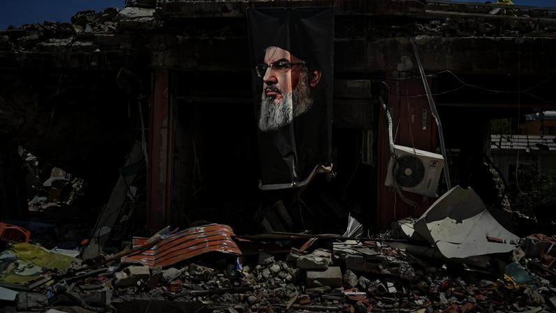 Faixa com a imagem de Hassan Nasrallah, líder assassinado do Hezbollah, pendurada em um prédio destruído na cidade de Jibchit, no sul do Líbano