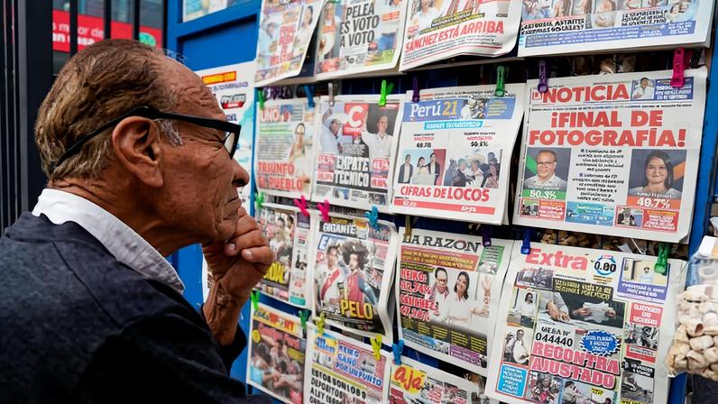 Homem observa manchetes com os primeiros resultados do segundo turno das eleições presidenciais entre a populista de direita Keiko Fujimori e o candidato de esquerda Roberto Sánchez