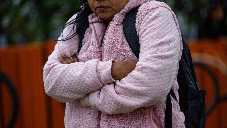 Em dia frio, mulher caminha no largo da Batata, zona oeste da cidade de São Paulo