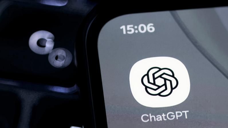 Tela de smartphone exibe o ícone do aplicativo ChatGPT com o horário 15:06 no canto superior esquerdo. Fundo da tela é cinza claro e o ícone é branco com símbolo preto entrelaçado.