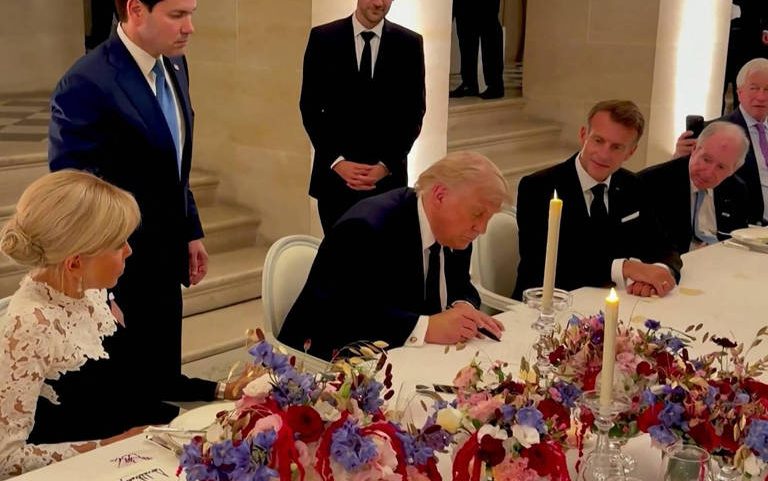 O presidente dos EUA, Donald Trump, assina o acordo com o Irã ao lado de seu homólogo francês, Emmanuel Macron, durante visita ao Palácio de Versalhes