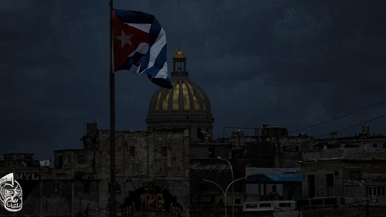 Prédio do Parlamento de Cuba em meio a outras construções com a bandeira do país em primeiro plano