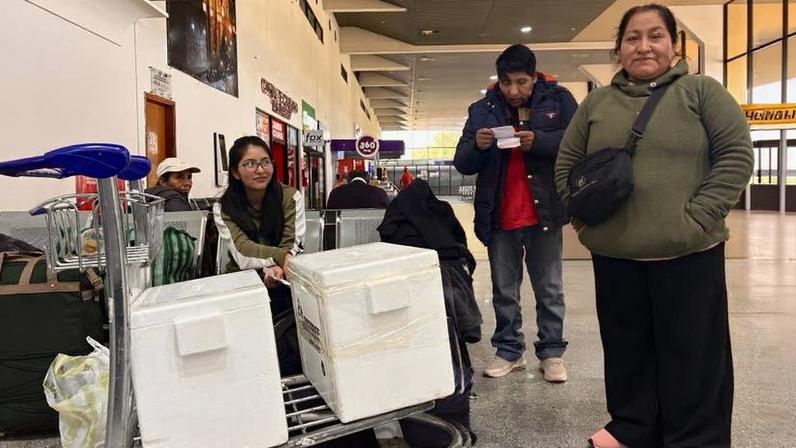 No saguão do Aeroporto Internacional Viru Viru, em Santa Cruz de La Sierra, uma família carrega caixas de isopor com frango, carne bovina e suína comprados a preços locais para serem levadas para cidades onde há escassez
