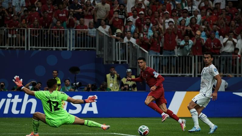 Cristiano Ronaldo observa a bola chutada por ele passar pelo goleiro do Uzbequistão no lance do seu segundo gol na goleada portuguesa no estádio NRG, em Houston
