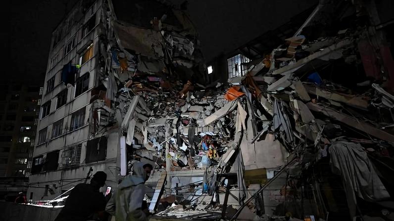 Moradores observam um prédio que desabou em Caracas após os terremotos que atingiram a Venezuela nesta quarta-feira (24)