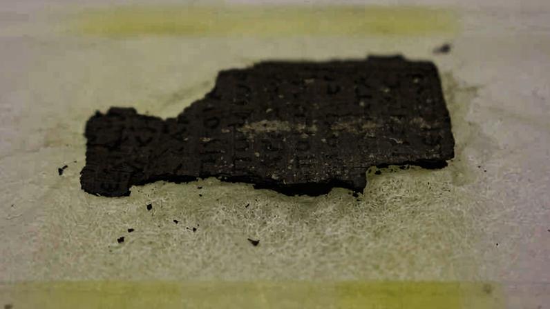 Fragmento do pergaminho de Herculano, queimado durante a erupção do Monte Vesúvio, em 79 d.C. Através do uso de ferramentas de inteligência artificial, pesquisadores conseguiram ler o texto virtualmente