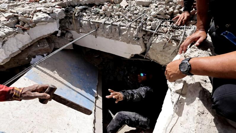 Socorristas trabalham para resgatar pessoas soterradas em escombros no estado de La Guaira, na Venezuela, após terremotos