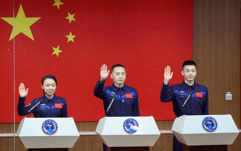 Os astronautas Zhu Yangzhu, Zhang Zhiyuan e Lai Ka-ying, que é o primeiro astronauta de Hong Kong, acenam enquanto participam de uma coletiva de imprensa antes da missão espacial Shenzhou-23 no Centro de Lançamento de Satélites de Jiuquan, próximo a Jiuquan, província de Gansu (China)