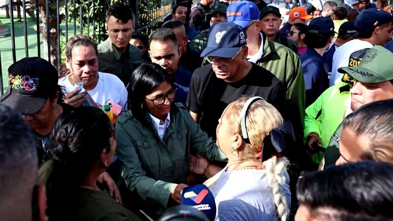A atual líder da Venezuela, Delcy Rodríguez (ao centro), e o presidente da Assembleia Nacional da Venezuela, Jorge Rodríguez, conversam com moradores em La Guaira