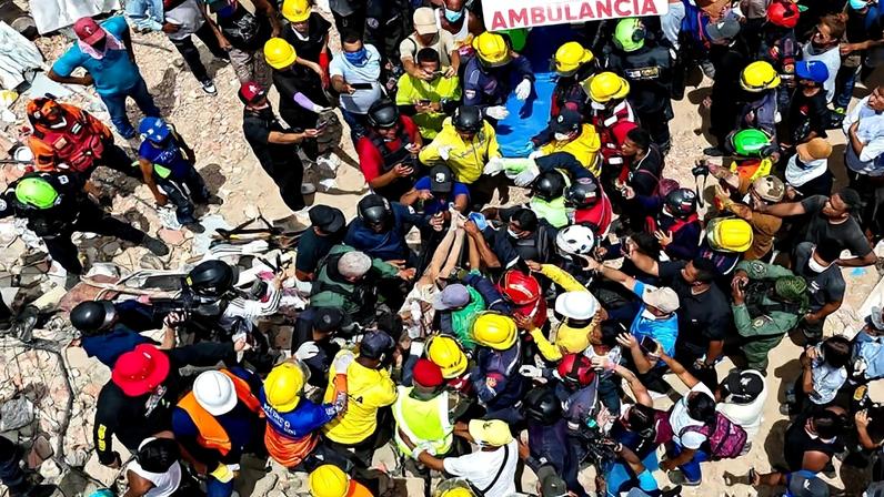 Vista aérea de equipes estrangeiras de resgate, da França e dos EUA, transportando uma vítima encontrada nos escombros de prédio em Caraballeda, no estado de La Guaira, na Venezuela