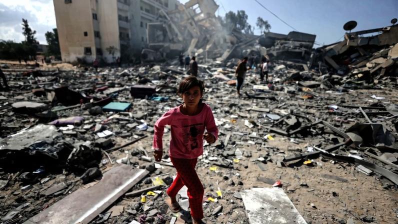 Uma menina caminha entre os escombros de edifícios residenciais após ataques aéreos israelenses no bairro de al-Zahra, na Faixa de Gaza, em 19 de outubro de 2023