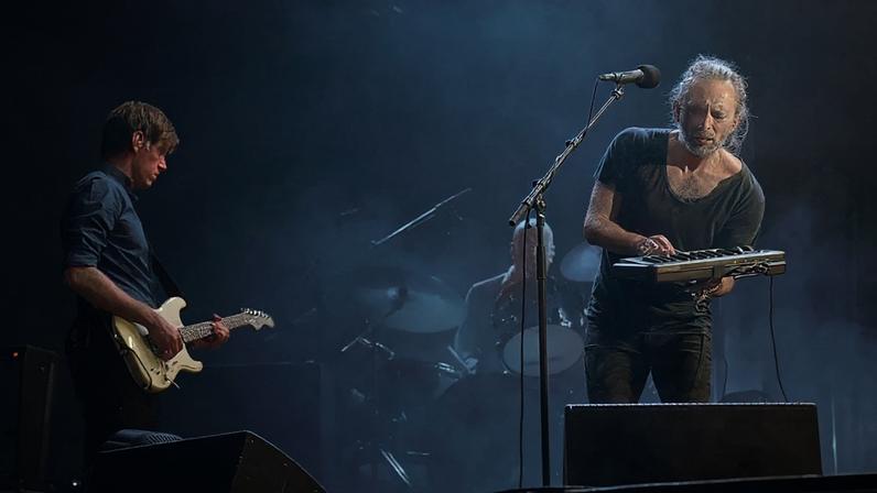 Ed O'Brien, Philip Selway (fundo) e Thom Yorke durante show do Radiohead em 2016 (