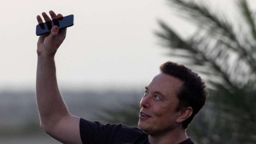 Elon Musk levanta seu telefone para o céu durante uma coletiva de imprensa na base Starbase da SpaceX, em Brownsville, Texas, EUA, em 25 de agosto de 2022.