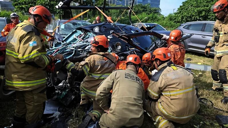 Agentes do corpo de bombeiros trabalham nos escombros de helicóptero envolvido em acidente