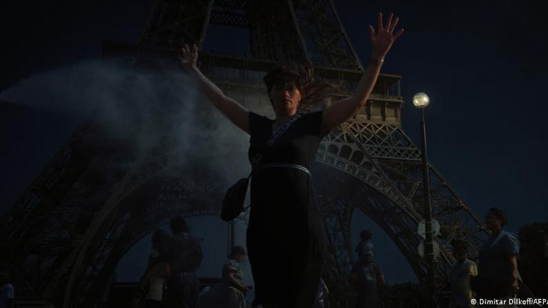 Turistas se refrescam com água diante da Torre Eiffel, em Paris